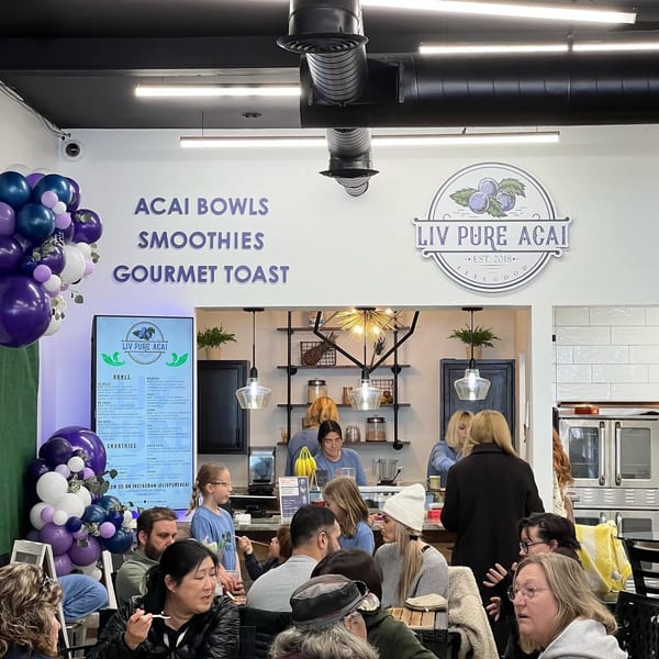 Customers enjoying acai bowls and smoothies inside Liv Pure Acai, a bright and modern cafe.
